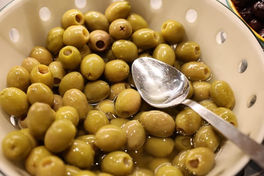 A beautifully presented bowl filled with vibrant, green olives, perfect for adding to salads or enjoying as snacks