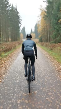 A cyclist riding through a scenic forest path during autumn, surrounded by vibrant fall foliage.