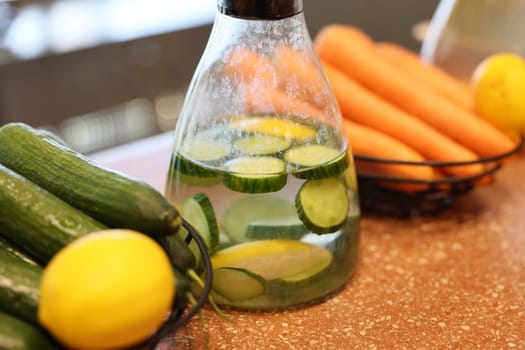 A vibrant and colorful mix of infused water featuring fresh cucumbers, zesty lemons, and crunchy carrots for hydration