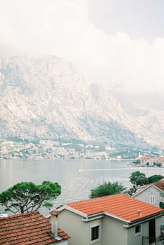 View over the red roofs of houses on the mountain range near the sea in the fog. High quality photo