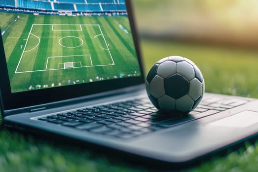 laptop displaying soccer field with ball on keyboard.
