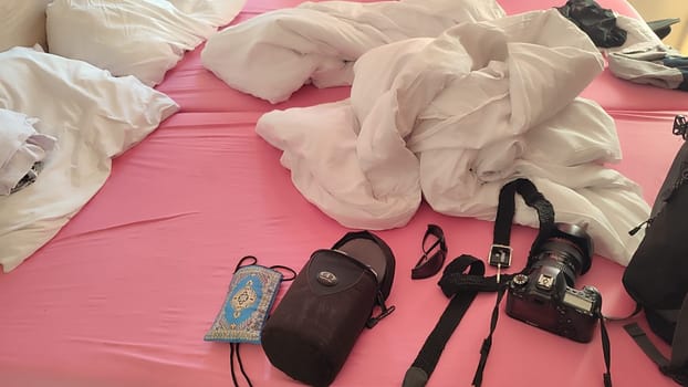 October 22 2024 Hradec Kralove, Czech Republic Europe, Kralov region, Kralovehradecky kraj, Canon 6D camera lies on the bed in white pink bed. High quality photo