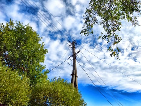 Old pole with wires against the sky. Electric transmission line, Eco-friendly energy