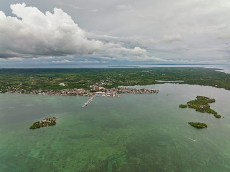 Aerial view of town on the seashore with a pier and fishermen's houses. Bantayan Island. Philippines.