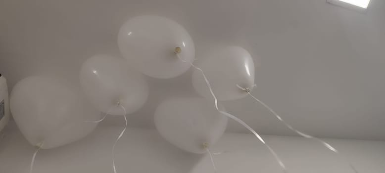 white heart shaped balloons hanging from ceiling, holiday objects. High quality photo