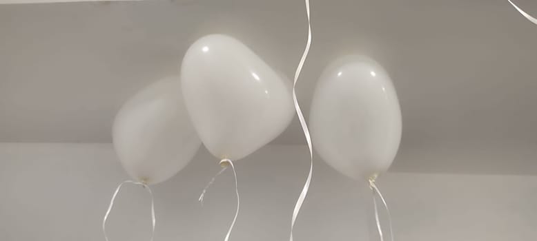 white heart shaped balloons hanging from ceiling, holiday objects. High quality photo