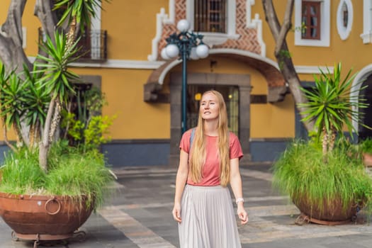 Female tourist walking through the colorful colonial streets of Puebla, Mexico. Travel, cultural exploration, and vibrant architecture concept.