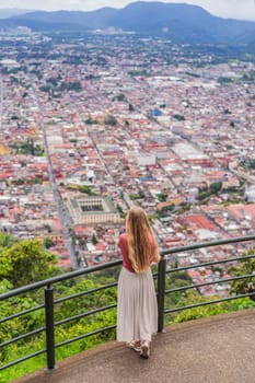 Female tourist in front of the panoramic view of Orizaba from Cerro del Borrego, Mexico. Travel, scenic landscape, and adventure concept.