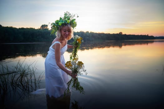 Girl in White Sundress With Flower Wreath in Water at Sunset Celebrating Ivan Kupala Holiday