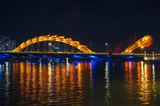 Dragon Bridge over the Han River in city of Da Nang in Vietnam at night with a golden backlight