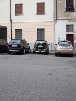 Cremona, Lombardy, Italy October 15th 2024 Parked cars in a residential area showing urban life with a camouflage painted smart car