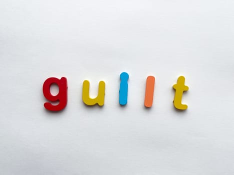 Colorful letters spelling guilt on plain white background.