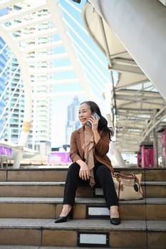 Successful middle aged businesswoman enjoying a phone conversation in modern city.