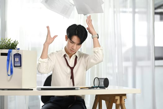 Frustrated office worker throwing documents in anger. Stress at work concept.