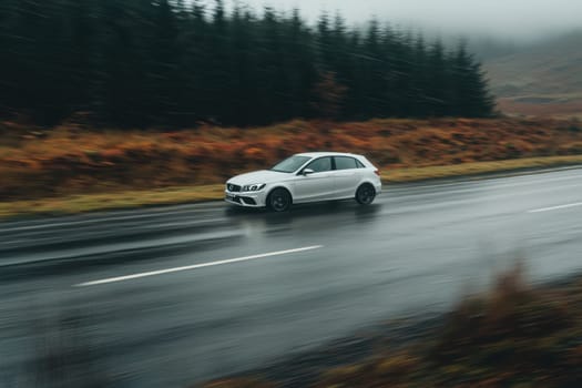 A fast-moving car creates a striking motion blur as it traverses an empty road surrounded by serene, foggy landscapes, embodying speed and freedom.