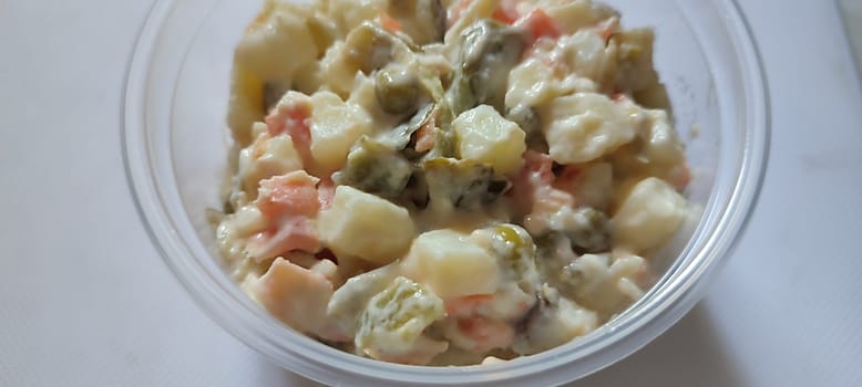 vegetable salad olivier with potatoes and mayonnaise in a plastic jar, food snack breakfast photo