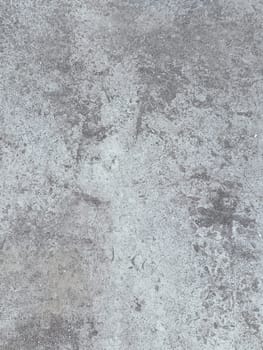A grey and white wall with a few spots of color. The wall is made of concrete and has a rough texture