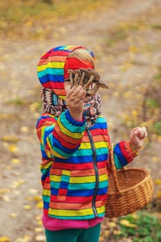 Child with mushrooms in the forest. Selective focus. nature.