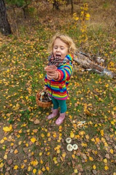 Child with a basket of mushrooms in the forest. Selective focus. nature.