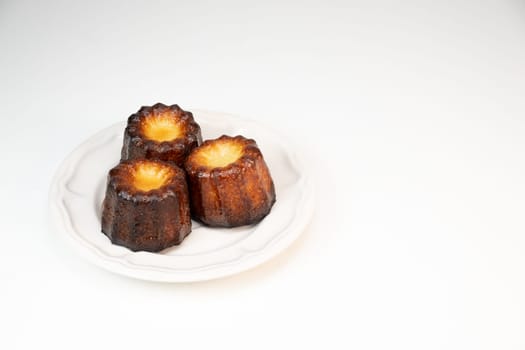 Caneles de bordeaux, traditional French sweet dessert with white table background, High quality photo