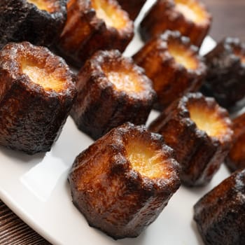 Caneles de bordeaux, traditional French sweet dessert with white table background, High quality photo