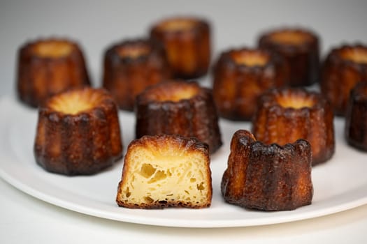 Caneles de bordeaux, traditional French sweet dessert with white table background, High quality photo