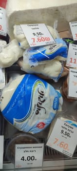 November 5 2024 Beer-Sheva city Israel, grocery store, different types of cheese on sale, labels with price . High quality photo