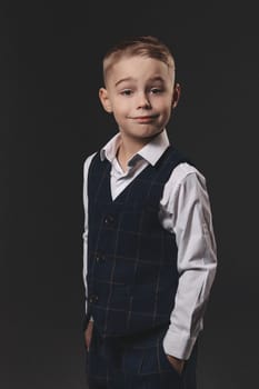 A handsome boy in a stylish outfit smiles, looks at the camera, poses.