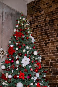 Christmas decor. Bedroom in dark colors with large bed. The interior is decorated with garlands and Christmas tree.