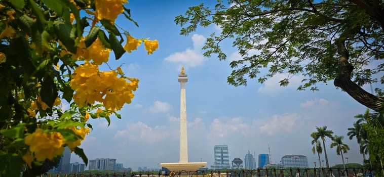 Jakarta city, Indonesia, 03 November 2024, Scenic view of the National Monument or Monas around city skyscrapers under a clear blue sky and sunny day, good for news article or multimedia content creation