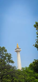 Jakarta city, Indonesia, 03 November 2024, Scenic view of the National Monument or Monas around city skyscrapers under a clear blue sky and sunny day, good for news article or multimedia content creation