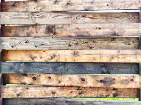 A collection of wooden boards is positioned horizontally, featuring various shades and grains, perfect for a design project or presentation backdrop.