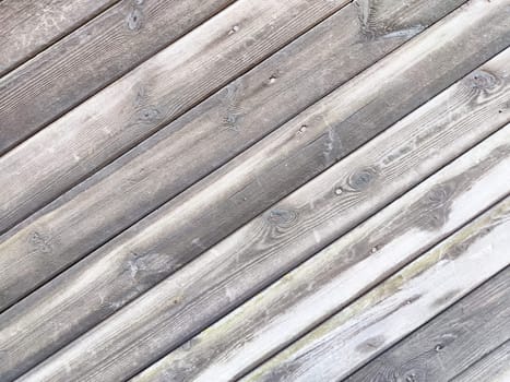 A textured wooden surface features diagonal planks, showcasing natural wear and providing a clean area for text or graphics.