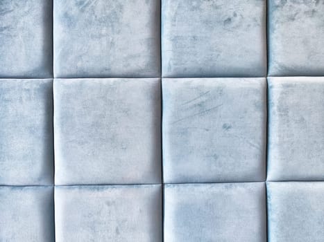 A modern living area features soft blue upholstered wall panels, providing a tranquil and stylish atmosphere for relaxation.