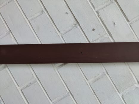 The image features a brown wooden beam set against a textured white brick surface, providing space for additional text or graphics.