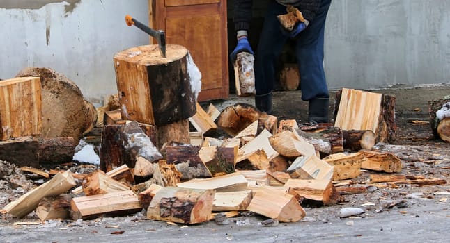 Old ax and a deck for chopping wood. Dry firewood, chopped wood for winter heating of the fireplace.