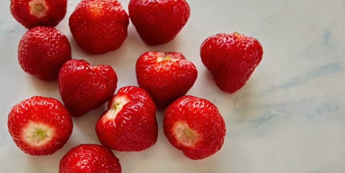 A bountiful display of freshly picked strawberries arranged in a decorative porcelain bowl on a sunny kitchen countertop