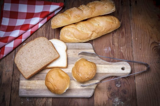 An overview of of various breads on a cutting board.