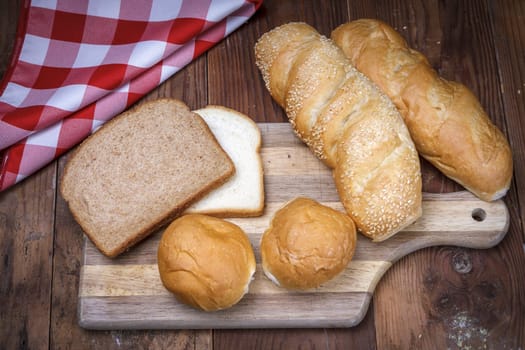 An overview of of various breads on a cutting board.