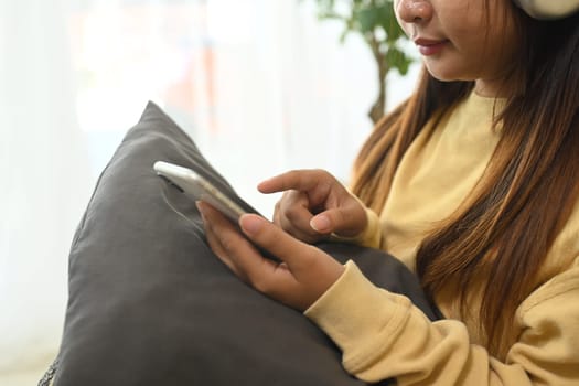 Close up of young woman reading text message, typing on her smartphone.