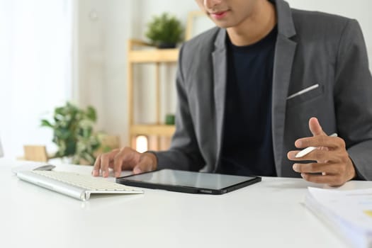 Young businessman using digital tablet at modern office.