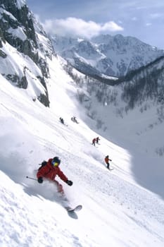 Mountain descent: snowboarder carving through fresh powder in winter mountains, capturing essence of outdoor sports and exhilaration of gliding down pristine slopes under sky