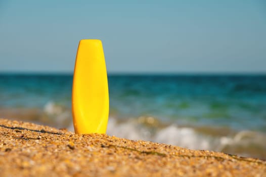 bright cream product packaging on the sea coast. empty bottle for advertising care cosmetics.