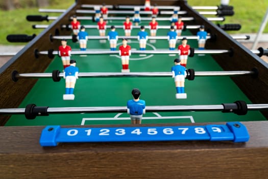 Table football. Close-up of figures of plastic players in a football match. red and blue players kick the ball.