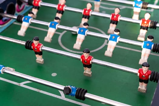 Table football. View of the football field and plastic players at a football match. red and blue players are hitting the ball. Championship. Entertainments