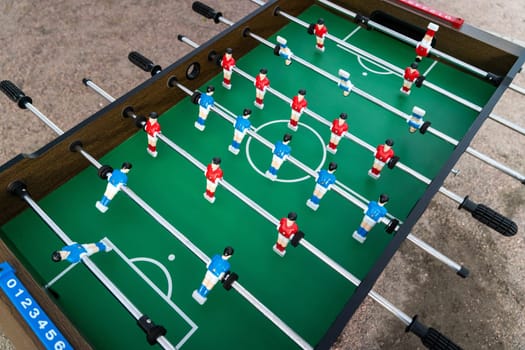 Table football. View of the football field and plastic players at a football match. red and blue players are hitting the ball. Championship. Entertainments