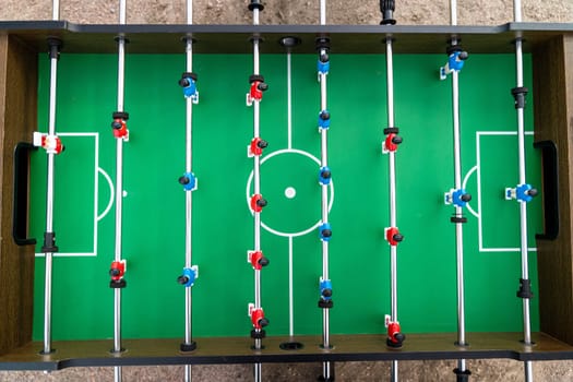 Table football. Top view of the football field and plastic players at a football match. red and blue players are hitting the ball. Championship