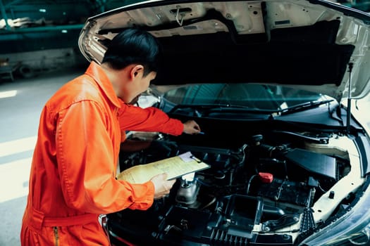 Automotive service mechanic inspect and diagnose car engine issue, repairing and fixing problem in garage workshop. Technician car care maintenance working on internal components of vehicle. Oxus
