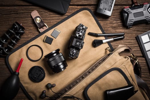 photography gear on wooden table, digital camera lens and other accessories.