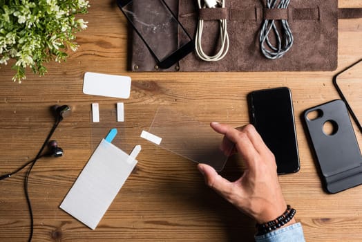 The man replacing the broken tempered glass screen protector for smartphone.